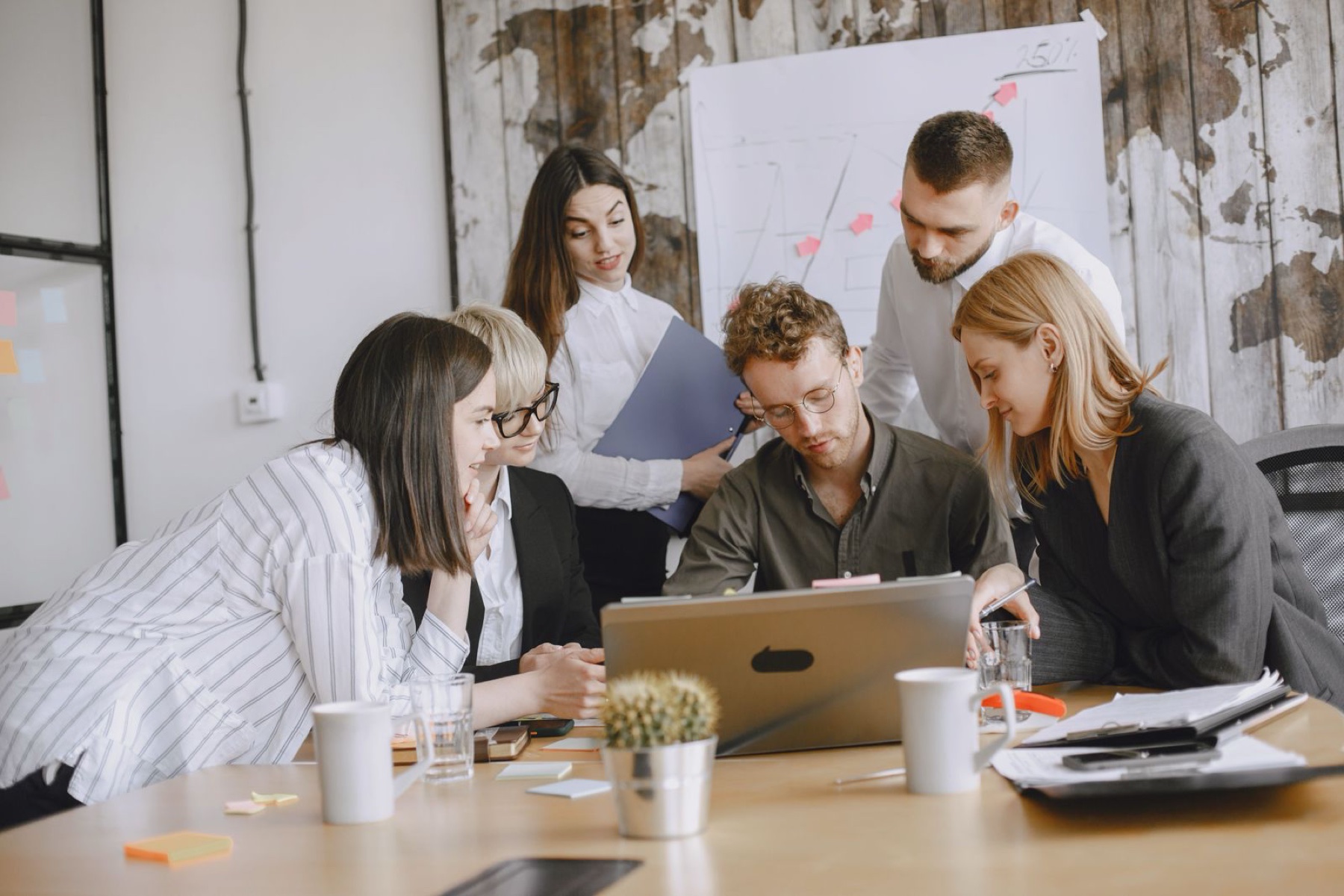Equipo de profesionales colaborando alrededor de una mesa de trabajo
